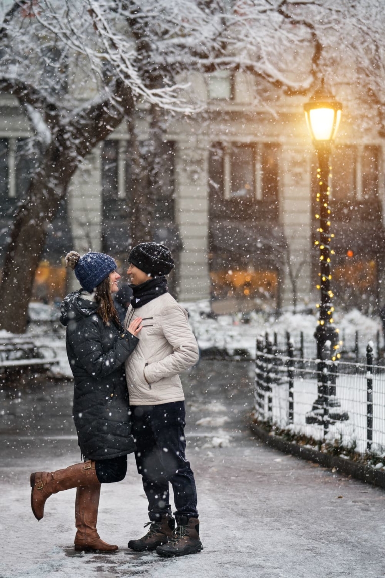 Engagement portrait in the snow by a bright lamp.