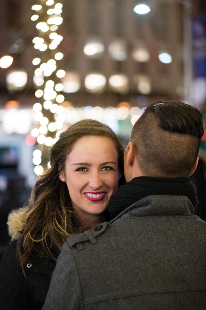 Woman smiles during embrace at Christmas.