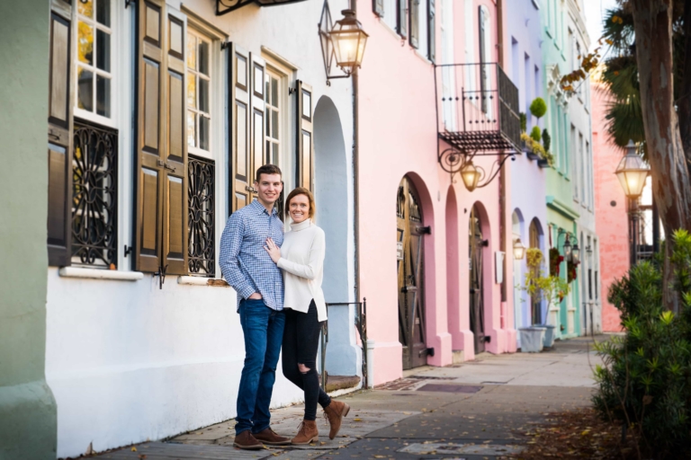 Engaged couple in front of colored houses