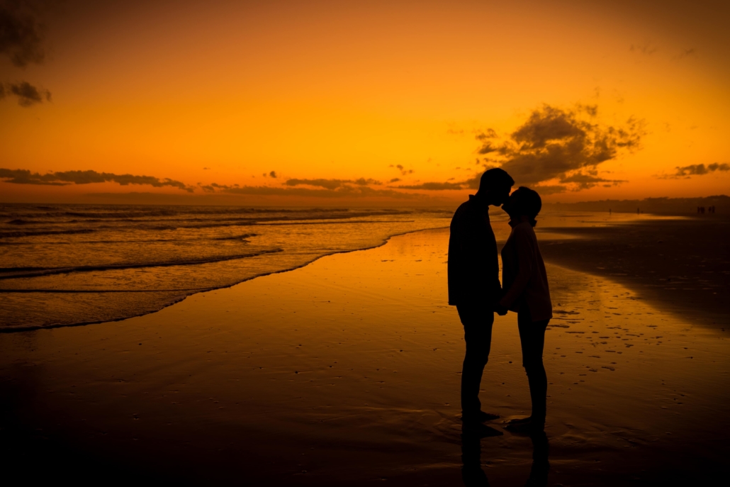 Silhouettes of people kissing on the beach
