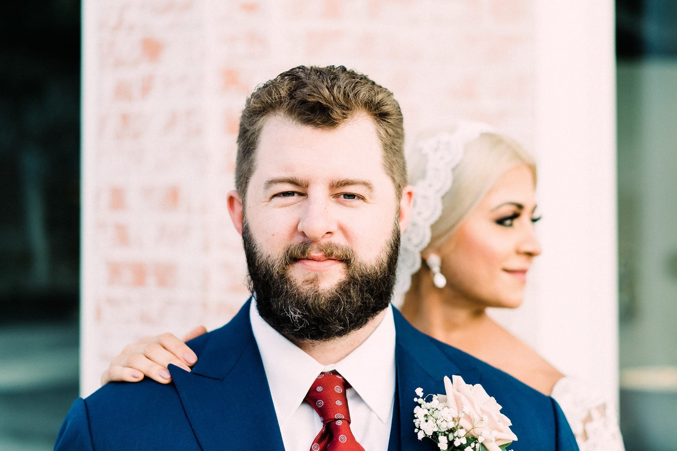 Groom stares into the camera while bride looks away.
