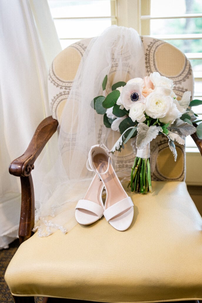 wedding shoes and flowers sitting in a chair